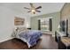 Cozy bedroom with hardwood floors, ceiling fan and a large window at 8847 Rose Hill Dr, Orlando, FL 32818