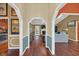 Hallway with hardwood floors, arched doorways, and view of the living room and kitchen at 8847 Rose Hill Dr, Orlando, FL 32818