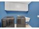 Laundry room with a modern washer, dryer, and ample storage cabinets at 8847 Rose Hill Dr, Orlando, FL 32818