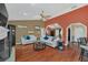 Bright, open living room with wood floors, white sofas and archways at 8847 Rose Hill Dr, Orlando, FL 32818