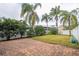 Expansive backyard featuring a paver patio, well-maintained lawn, mature trees, and a white fence at 7036 Mapperton Dr, Windermere, FL 34786