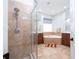 This bathroom features a glass enclosed shower, tile flooring, dual shower heads, soaking tub, and wooden vanities at 7036 Mapperton Dr, Windermere, FL 34786
