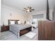 Stylish bedroom with a bed, ceiling fan, a dresser with a TV, and bright window at 7036 Mapperton Dr, Windermere, FL 34786