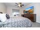 Stylish bedroom with a bed, ceiling fan, a dresser with a TV, and bright window at 7036 Mapperton Dr, Windermere, FL 34786