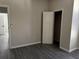 Bedroom featuring wood-look flooring, a door, and neutral paint, creating a cozy retreat at 7036 Mapperton Dr, Windermere, FL 34786