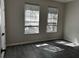 Bedroom with gray wood-look flooring and two bright windows, offering a peaceful space at 7036 Mapperton Dr, Windermere, FL 34786
