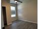 Bedroom showcasing gray wood-look flooring, a ceiling fan, and bright window, enhancing comfort at 7036 Mapperton Dr, Windermere, FL 34786