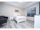 Bright main bedroom with grey wood floors, tray ceiling, a white bed, and a sitting area at 7036 Mapperton Dr, Windermere, FL 34786