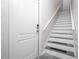 Bright staircase featuring white risers, gray treads, a white handrail, and natural light at 7036 Mapperton Dr, Windermere, FL 34786