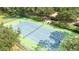 Aerial shot of tennis court with lush green surrounding landscaping at 7036 Mapperton Dr, Windermere, FL 34786