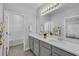 Bathroom featuring double sinks with white countertops, gray cabinets and a large mirror and towel rack at 29912 Cypress Pointe, Deer Island, FL 32778