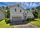 Inviting two-story home with a stone-accented entrance and a brick driveway, offering both charm and sophistication at 29912 Cypress Pointe, Deer Island, FL 32778