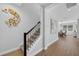 A bright hallway with wood floors, a staircase, art and a view of the dining room, offering a warm welcome at 29912 Cypress Pointe, Deer Island, FL 32778