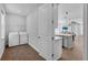 Laundry room with washer, dryer, storage, and adjacent view into kitchen area at 29912 Cypress Pointe, Deer Island, FL 32778