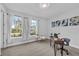 An elegant office with natural light, neutral tones, a modern desk, and views of the serene neighborhood at 29912 Cypress Pointe, Deer Island, FL 32778