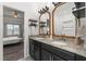 Granite-topped double vanity bathroom with sleek black cabinets and decorative mirrors at 1548 Astoria Arbor Ln, Orlando, FL 32824