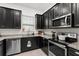 A modern kitchen featuring granite countertops, stainless steel appliances, and sleek black cabinetry at 1548 Astoria Arbor Ln, Orlando, FL 32824