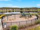 Community playground with swings and play structure near the lake with benches, surrounded by a fence and landscaping at 1548 Astoria Arbor Ln, Orlando, FL 32824