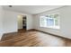 Living room with hardwood floors, view to kitchen, and large window at 1228 Se 17Th St, Ocala, FL 34471