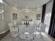 Modern dining room with glass table, white chairs, and geometric wall design at 2621 Lookout, Kissimmee, FL 34746