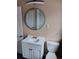 Bright bathroom featuring a modern vanity, toilet, circular mirror, and tiled shower at 3110 Port Royal Dr, Orlando, FL 32827