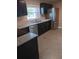 Well-lit kitchen with black cabinets, stone countertops, stainless steel fridge, and polished concrete floors at 3110 Port Royal Dr, Orlando, FL 32827