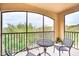 Private screened-in balcony with a table and chairs overlooking the lush greenery outside at 1301 Tuscan Ter # 9401, Davenport, FL 33896