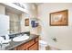 A bathroom features a shower with glass doors, a toilet, a sink and vanity with granite counters and a picture at 1301 Tuscan Ter # 9401, Davenport, FL 33896