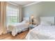 Bright bedroom with two twin beds, hardwood floors, light green walls and natural light from the window at 1301 Tuscan Ter # 9401, Davenport, FL 33896