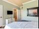 Cozy bedroom with mounted TV, dresser, and view into a tiled bathroom at 1301 Tuscan Ter # 9401, Davenport, FL 33896