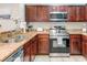 Modern kitchen with stainless steel appliances, granite counters, and dark wood cabinetry at 1301 Tuscan Ter # 9401, Davenport, FL 33896