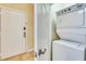 Laundry room with stackable washer and dryer unit next to an entry door with security features at 1301 Tuscan Ter # 9401, Davenport, FL 33896