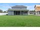 View of backyard with a large sliding glass door from the house to the green lawn at 3022 Peel Ave, Orlando, FL 32806
