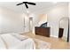 A clean and spacious bedroom with light wood floors, a modern ceiling fan, and artwork at 3022 Peel Ave, Orlando, FL 32806