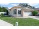 Tan one story house with a white garage door and landscaped lawn at 2907 Willow Oak Ct, Kissimmee, FL 34744