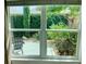 View of backyard oasis through a window with a chair at 2292 Richey Rd, The Villages, FL 32163