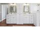 Elegant bathroom with double vanity, large mirrors, and white cabinetry at 12943 Se Sunset Harbor Rd, Weirsdale, FL 32195