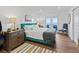 Bright bedroom with water views, teal bed, and wood floors at 12943 Se Sunset Harbor Rd, Weirsdale, FL 32195