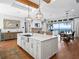 Modern kitchen with large island, white cabinets, and exposed beams at 12943 Se Sunset Harbor Rd, Weirsdale, FL 32195