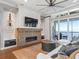 Living room features a brick fireplace, large TV, and hardwood floors at 12943 Se Sunset Harbor Rd, Weirsdale, FL 32195
