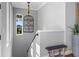Elegant staircase with a unique birdcage chandelier and wooden bench at 12943 Se Sunset Harbor Rd, Weirsdale, FL 32195