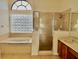A bright primary bathroom featuring a separate shower and soaking tub under a window at 510 Coventry Rd, Davenport, FL 33897