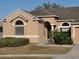 Tan house with arched entryway and well-maintained landscaping at 510 Coventry Rd, Davenport, FL 33897
