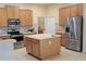 Spacious kitchen featuring wood cabinets, an island, stainless steel appliances, tile backsplash and flooring and lots of room at 510 Coventry Rd, Davenport, FL 33897
