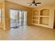 Bright living room featuring tile flooring, custom shelving, neutral paint and a ceiling fan, offering a cozy space for relaxation at 510 Coventry Rd, Davenport, FL 33897