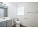 Bathroom with toilet, vanity, and window at 1316 Hackett St, Mount Dora, FL 32757