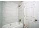 Bathroom featuring a bathtub, shower, and marble-look tile at 1316 Hackett St, Mount Dora, FL 32757