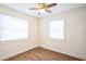 Bright bedroom with wood-look flooring, ceiling fan, and two windows at 1316 Hackett St, Mount Dora, FL 32757