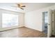 Bright bedroom with wood-look floors, ceiling fan and window at 1316 Hackett St, Mount Dora, FL 32757