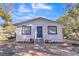 Newly renovated home with white siding, gray door, and landscaped yard at 1316 Hackett St, Mount Dora, FL 32757